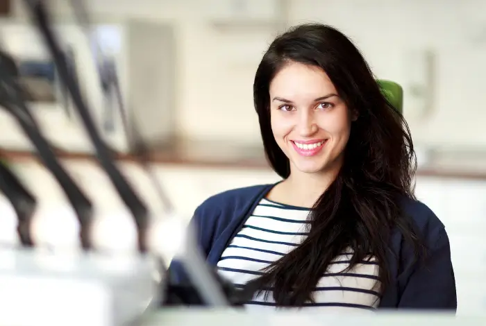 Woman smiling in dental chair after periodontal therapy in San Antonio