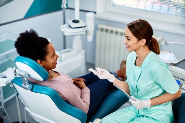 a person on a dentist's chair talking to the dentist