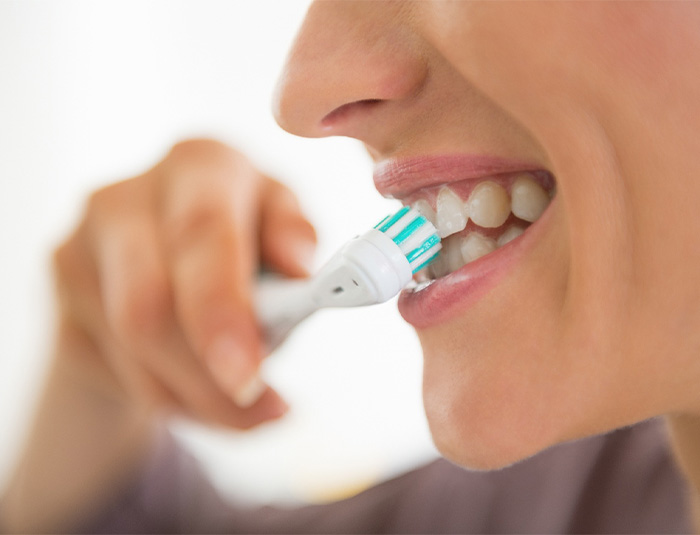 Close-up of woman brushing her teeth.