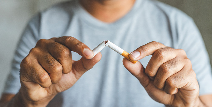 Closeup of patient breaking cigarette.