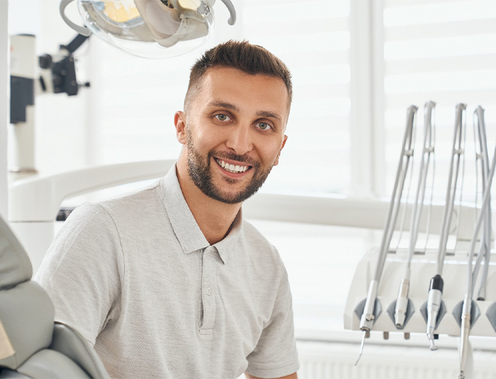 Man sitting in dental chair smiling.