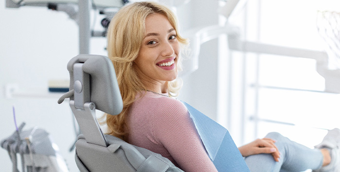 Patient smiling while sitting in treatment chair.